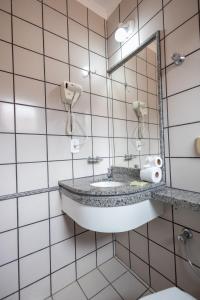 a bathroom with a sink and a mirror at DiRoma Fiori Hotel - BVTUR in Caldas Novas