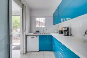 une cuisine bleue et blanche avec des armoires bleues dans l'établissement Jolie maison au Bouscat avec jardin, à Le Bouscat