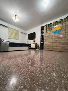 a living room with a concrete floor and a tv at Playa y Campo Balcony Studio in Isabela