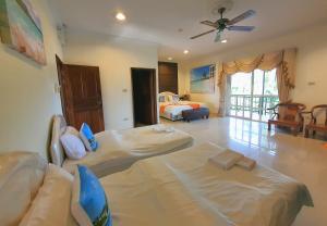 a hotel room with two beds and a ceiling fan at Serene Sands in Bang Lamung
