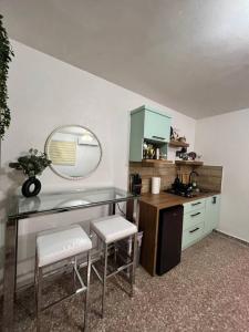 een keuken met een bureau met 2 stoelen en een spiegel bij Playa y Campo Balcony Studio in Isabela