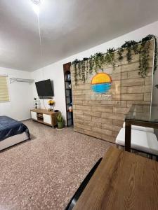 een slaapkamer met een muur met een regenboog erop bij Playa y Campo Balcony Studio in Isabela