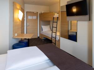 um pequeno quarto com uma cama e um beliche em B&B Hotel Fulda-City em Fulda