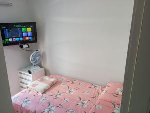 um quarto com uma cama e uma televisão de ecrã plano em Ótimo Apartamento vista mar a 70 metros em Itapema