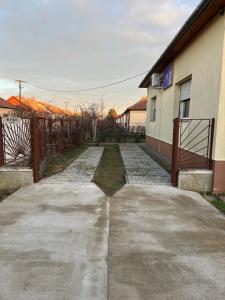 a driveway in front of a house with a fence at Abigél Apartman in Mórahalom