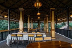 a restaurant with tables and chairs on a deck at สวนส่อผ่า&ฟาร์มสเตย์ in Mae Sai