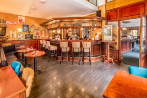 een bar in een restaurant met tafels en stoelen bij Summio Landgoed Het Grote Zand in Hooghalen