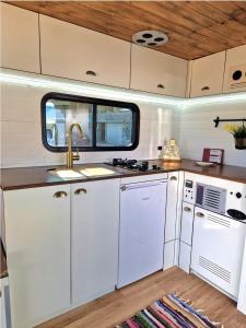 an rv kitchen with white cabinets and a sink at Camper estatico solo para alojar en el frente del Mar in La Tejita