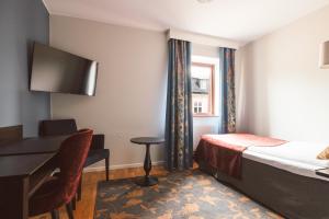 a hotel room with a bed and a desk and a computer at Clarion Collection Hotel Kung Oscar in Trollhättan