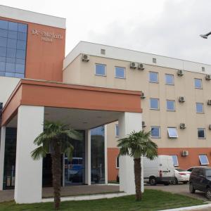 un edificio con dos palmeras delante en DE STEFANI HOTEL, en Portão