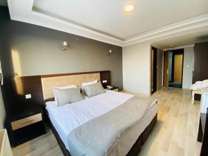 una camera da letto con un grande letto con lenzuola bianche di ANİMOS BUTİK OTEL a Ankara