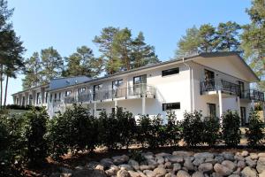 an exterior view of a white building with trees at Privat & Boutique Hotel Plauer See in Funfseen