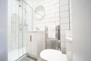 a white bathroom with a toilet and a shower at Belfry House in Bristol