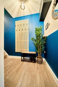 une chambre bleue avec un banc et une plante dans l'établissement Belfry House, à Bristol