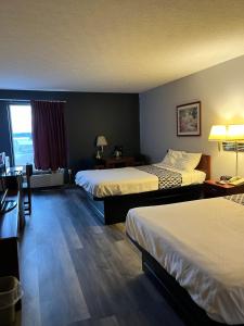 a hotel room with two beds and a desk at Springfield Inn in Springfield