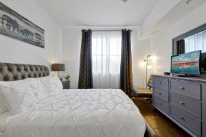 International Drive Luxury Condo في أورلاندو: غرفة نوم مع سرير وخزانة مع تلفزيون