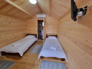 a room with two beds in a wooden cabin at POIANA MARAMURESEANA in Călimăneşti