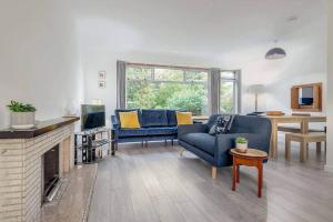 een woonkamer met blauwe meubels en een open haard bij Greentiles - Spacious House - Extensive Garden - Convenient Location in St Andrews