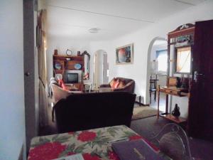 a living room with a couch and a table at Redwood Holiday Apartment in Jeffreys Bay