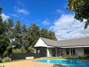 a house with a swimming pool in front of it at Lynx Wine Estate in Franschhoek