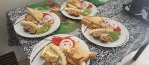 four plates of sandwiches and vegetables on a table at HARRIET APARTHOTEL Kigali-NYARUTARAMA in Kigali