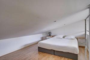 een slaapkamer met een wit bed met witte lakens bij Charmante petite maison de ville Bordeaux, Talence in Talence