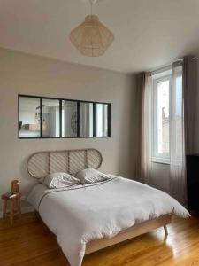 a bedroom with a bed with white sheets and a window at Chez Julie in Castres