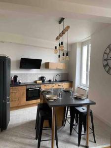 a kitchen with a table with chairs and a stove at Chez Julie in Castres