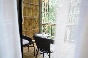 a room with a table and chairs and a window at สวนส่อผ่า&ฟาร์มสเตย์ in Mae Sai