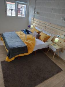 a large bed in a room with a table on it at Playa de Carnota Lofts in Pedrafigueira