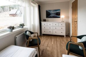 JärpenにあるHållandsgårdenのベッドとドレッサーと窓のある寝室