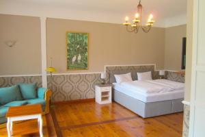 une chambre avec un lit, un canapé et une chaise dans l'établissement Landhotel Gut Zarrentin, à Gransebieth