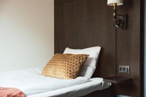 a bedroom with a bed with a pillow on it at Clarion Collection Hotel Kung Oscar in Trollhättan