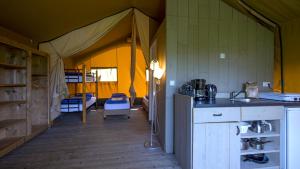 a tent with a kitchen and a sink in a room at Camping De Boerinn in Kamerik