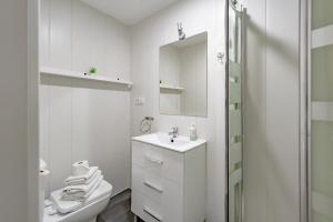 a white bathroom with a toilet and a sink at Apartamentos Preciados in Madrid +1 photo