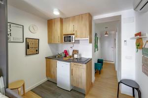a kitchen with wooden cabinets and a counter top at Apartamentos Preciados in Madrid