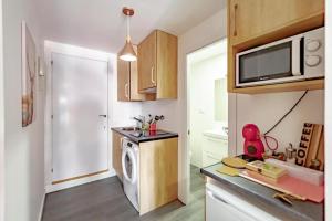 a small kitchen with a washing machine in it at Apartamentos Preciados in Madrid