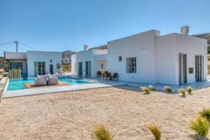 a villa with a swimming pool in the desert at Lil Paros Luxury suites in Dhragoulás
