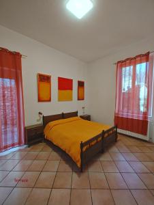 1 dormitorio con 1 cama y 2 ventanas en Casa al Campanile, LeonardosHome, en Trarego