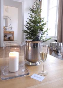 a table with a christmas tree and a candle and wine glasses at La Place B&B in Sancerre