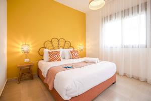 a bedroom with two beds and a yellow wall at Delmare 3BR Apartment in Batroun in Batroûn