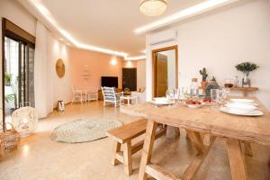 a dining room and living room with a wooden table at Delmare 3BR Apartment in Batroun in Batroûn