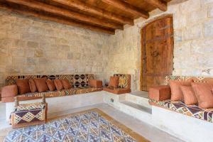 a living room with couches and a wooden door at Authentic Villa with Pool and Garden in Beit Chabeb 