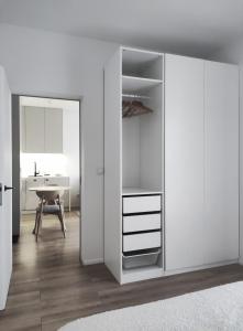 a room with a closet with white walls and a table at JAPANDI Apartament Modlińska Żerań in Warsaw