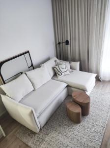 a living room with a couch and a stool at JAPANDI Apartament Modlińska Żerań in Warsaw