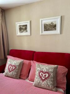 a bedroom with a red bed with two pictures on the wall at Alpine Studio with Garage in Breuil