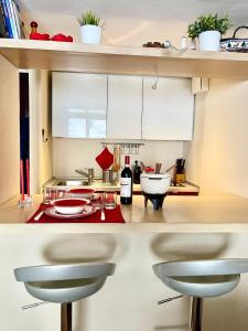 Una cocina con gabinetes blancos y una encimera con taburetes. en Alpine Studio with Garage, en Breuil