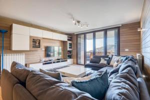 a living room with a large couch and a kitchen at Hert 3Bedroom Villa In Faraya in Brummānā