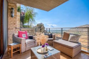 ein Wohnzimmer mit Sofas und einen Balkon mit Aussicht in der Unterkunft Hert 3Bedroom Villa In Faraya in Brummānā