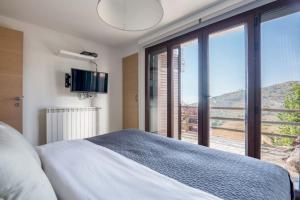 a bedroom with a bed and a large window at Hert 3Bedroom Villa In Faraya in Brummānā